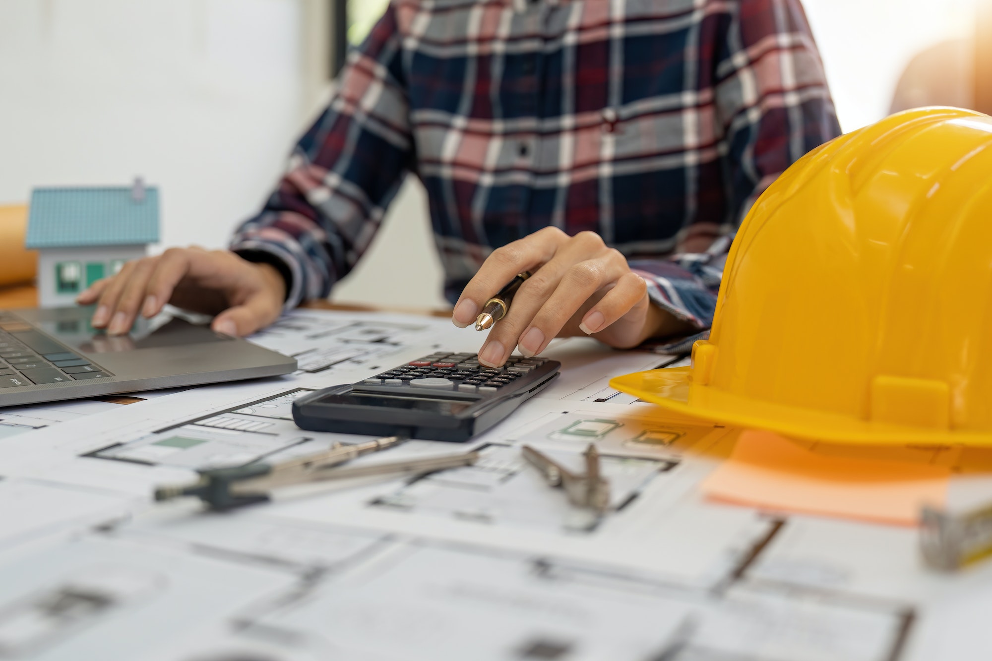 Close up Architect or Engineer using on calculator for calculating value estimating for safety with