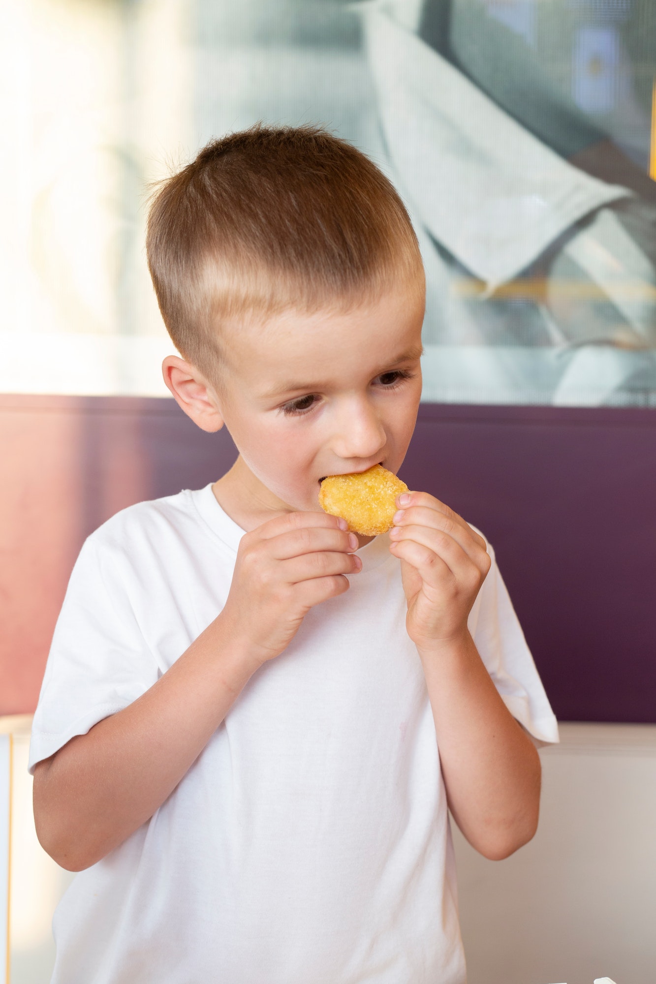 little boy eating nuggets