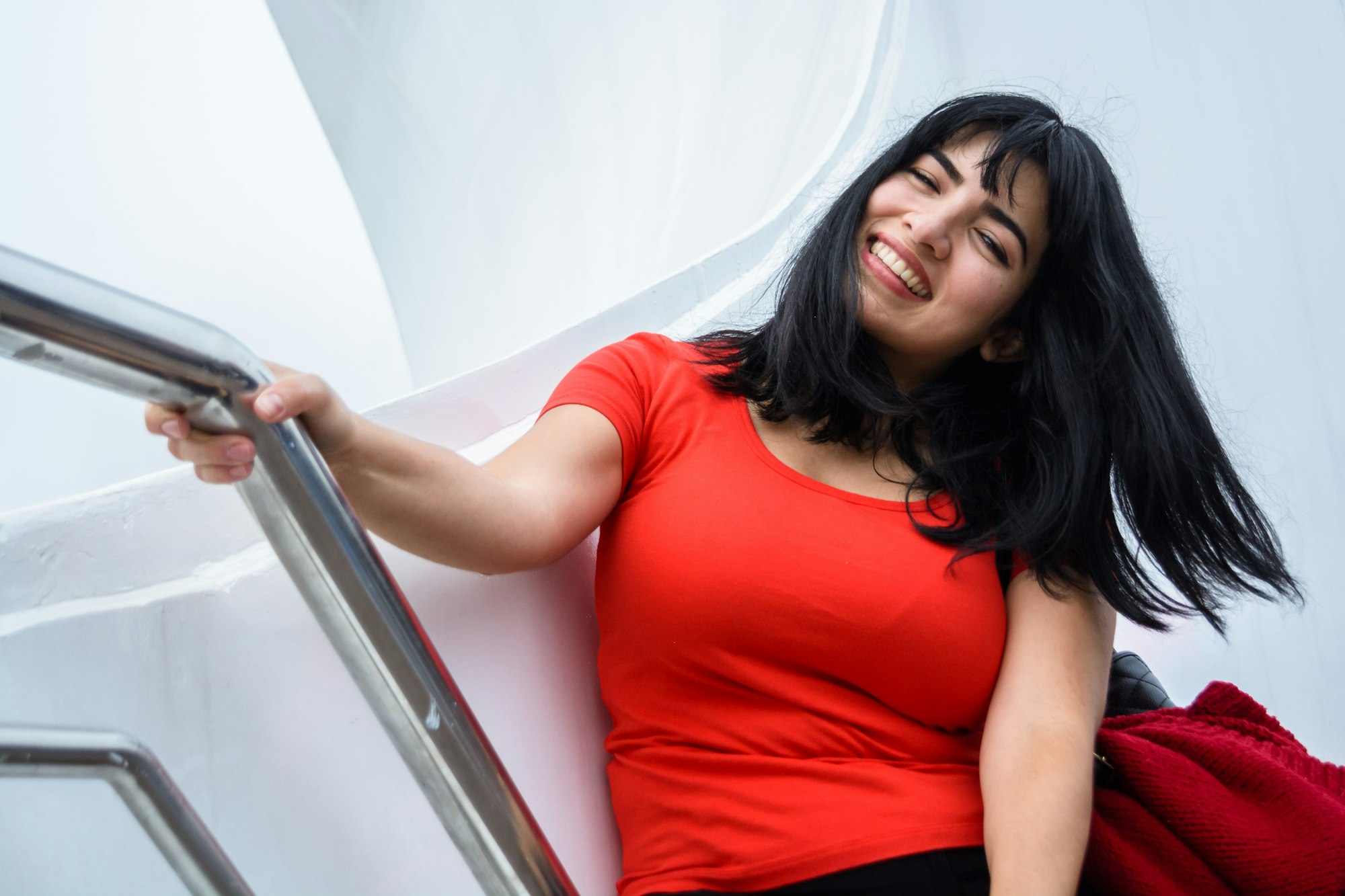 young latin woman sitting on Puente De La Mujer in Buenos Aires, smiling enjoying the vacation day.