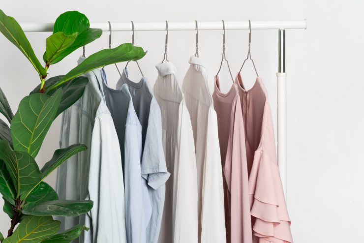 Women's casual clothes in soft pastel colors on a gray metal hanger on a stand, hanger